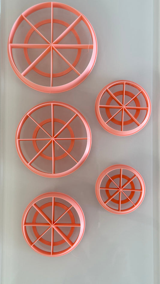 Five pink polymer clay color wheel cutters in multiple sizes designed for measuring and cutting equal clay portions for color recipes.