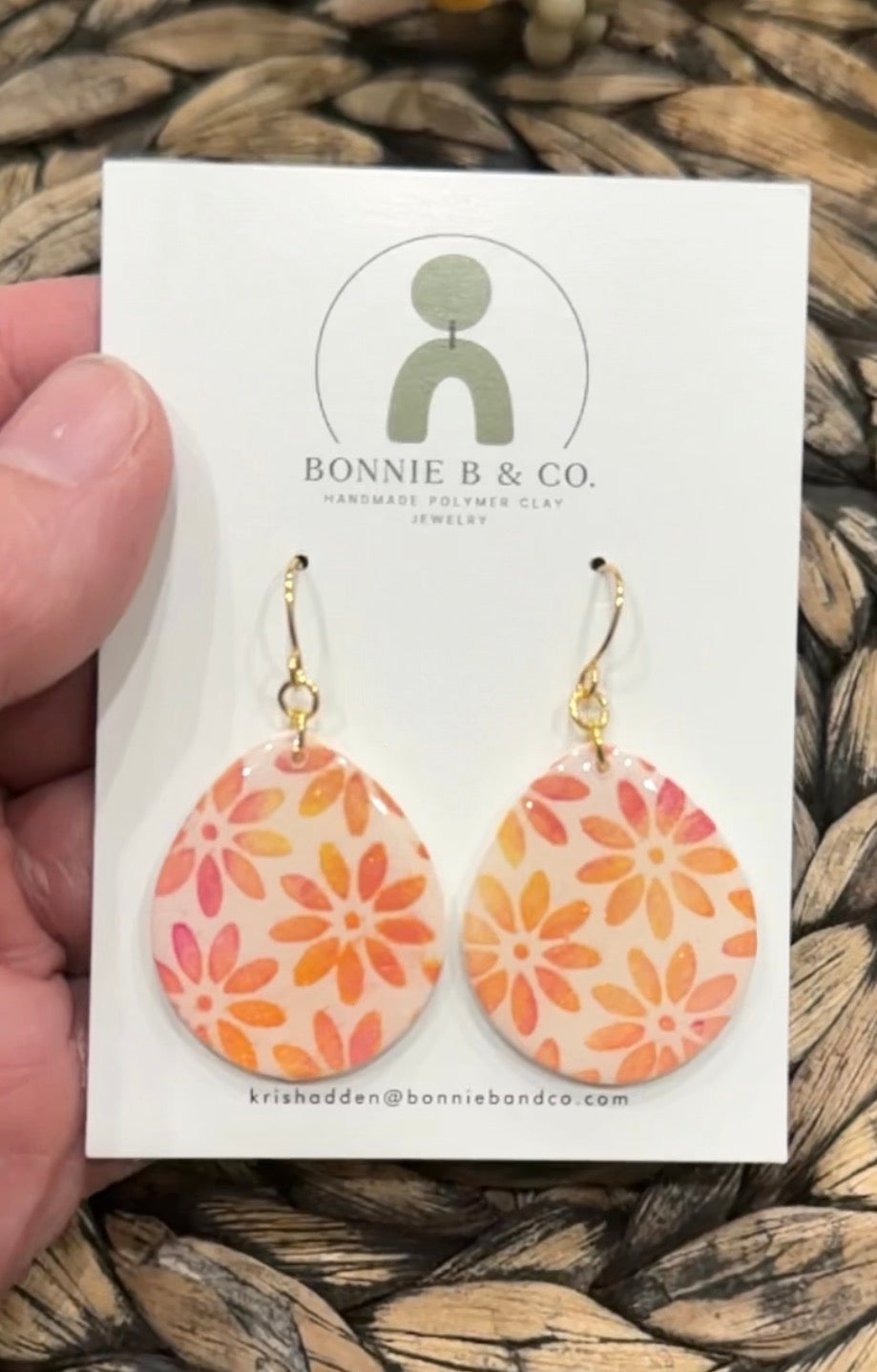 Marigold Teardrops handmade floral polymer clay earrings with warm orange and pink flowers on a translucent base, displayed on a Bonnie B & Co earring card