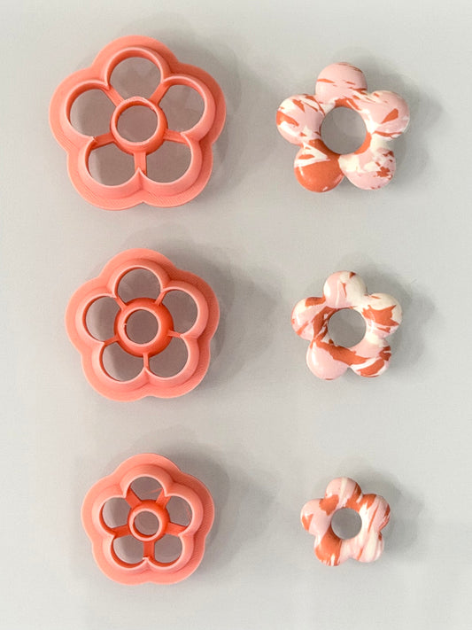 Pink daisy polymer clay cutter set in three sizes with floral clay examples.