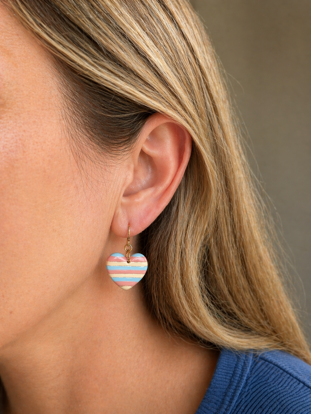 Lightweight southwestern heart dangle earrings worn, featuring earthy striped polymer clay and gold hooks