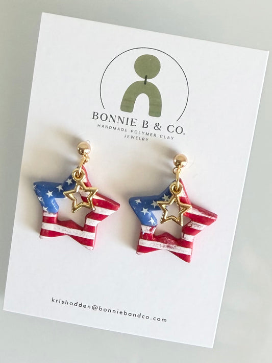 Handmade patriotic polymer clay star earrings featuring red white and blue American flag design with gold star charms.