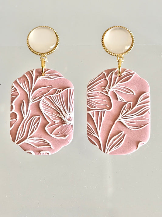 Handmade dusty rose polymer clay earrings with white floral carved design and gold accents